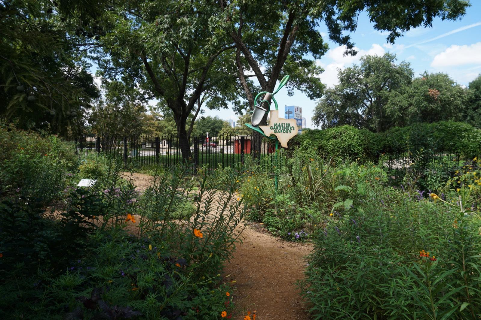 Master Gardeners' Garden at Texas Discovery Gardens with planted beds, a path, and a garden sign