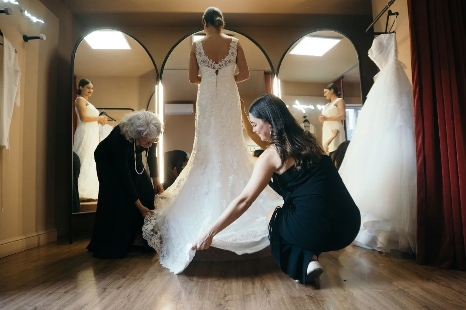 Photo by Los Muertos Crew on Pexels A bride stands in a fitting room while two attendants adjust her white wedding dress.