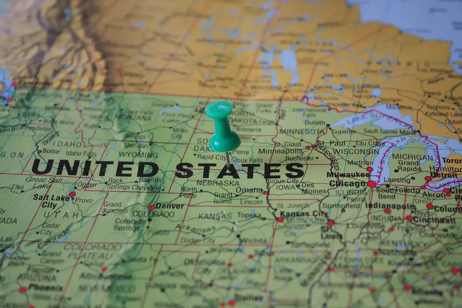 Photo by Beate Vogl on Pexels A green push pin marks a spot on a paper map of the United States.