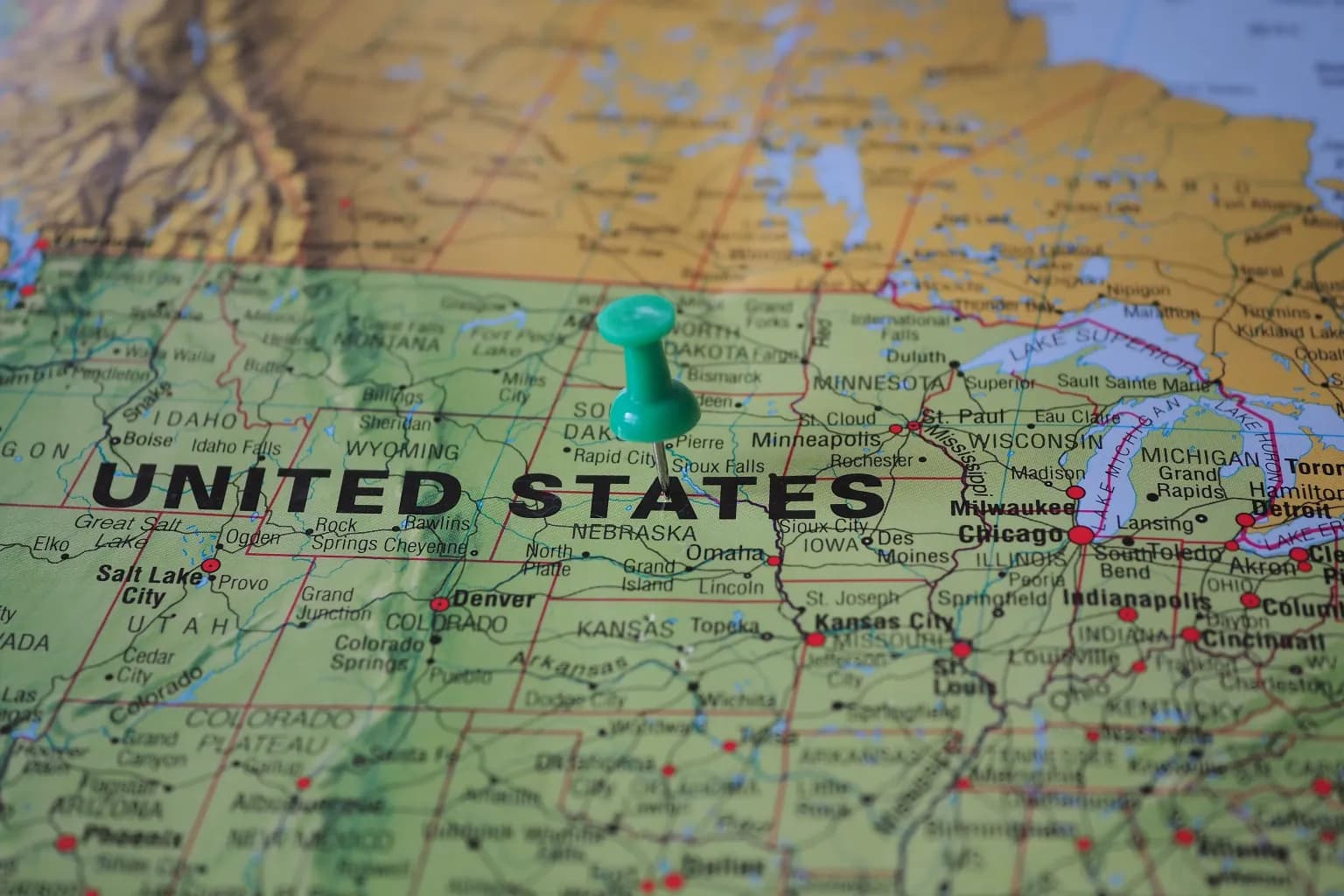 Photo by Beate Vogl on Pexels A green push pin marks a location on a paper map of the United States.