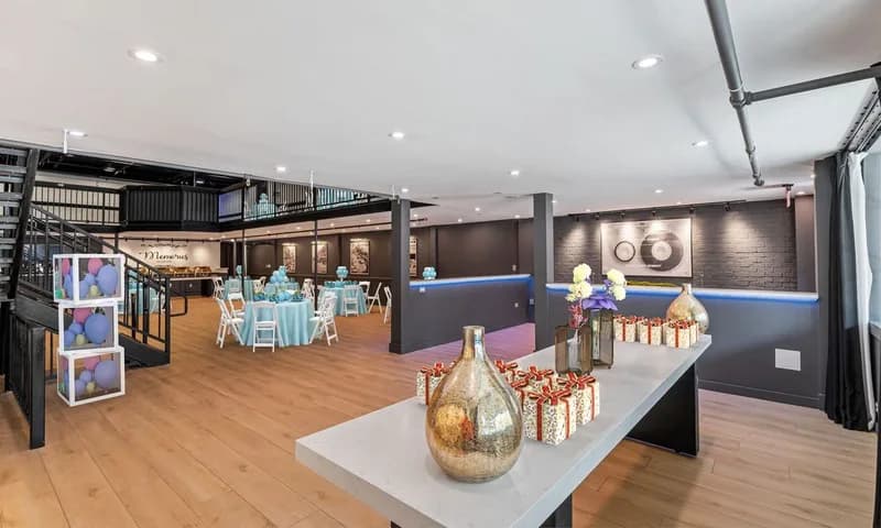 Event room with wood floors and tables arranged for a celebration