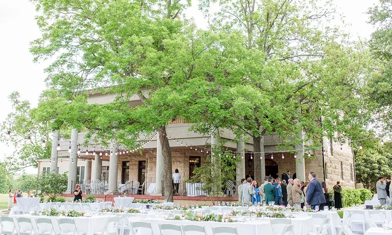 Outdoor reception tables beside the stone mansion