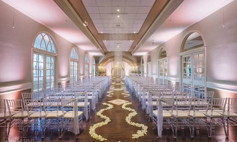 Ceremony seating inside a hall with arched windows